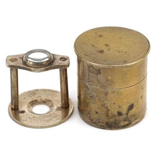 1190 - A brass cased stamp magnifier, circa 1920, enclosing a platform fitted with a lens, diameter 25mm.