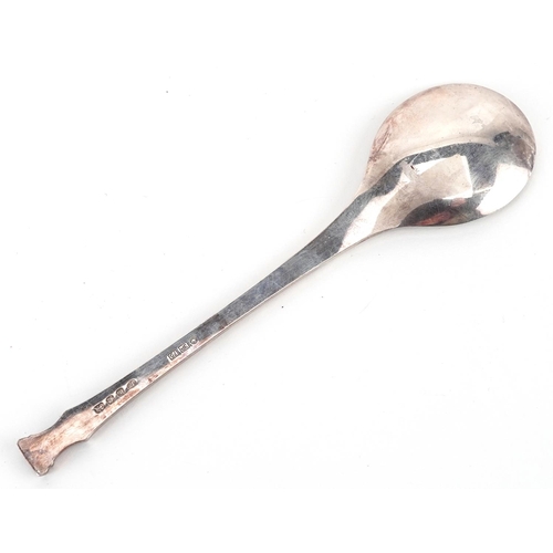 559 - A silver Christmas spoon, London 1975, the bowl cast with Victorian carol singers, the stem cast wit... 