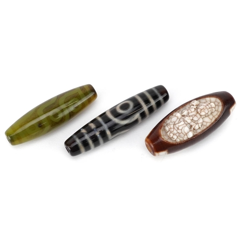 305 - Three Chinese polished stone beads, 20th century, the largest 6cm in length.