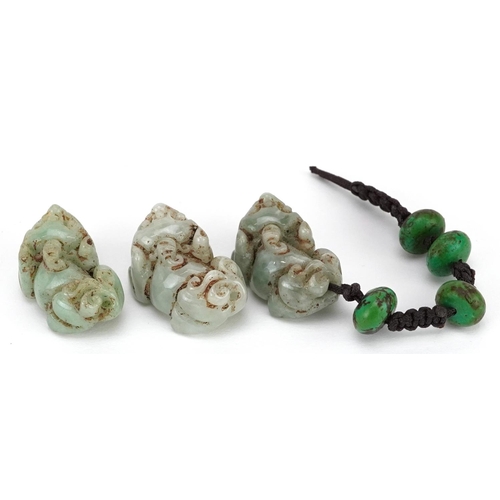 307 - Three Chinese carved celadon jade beads in the form of Foo dogs, early 20th century, 2cm in length.