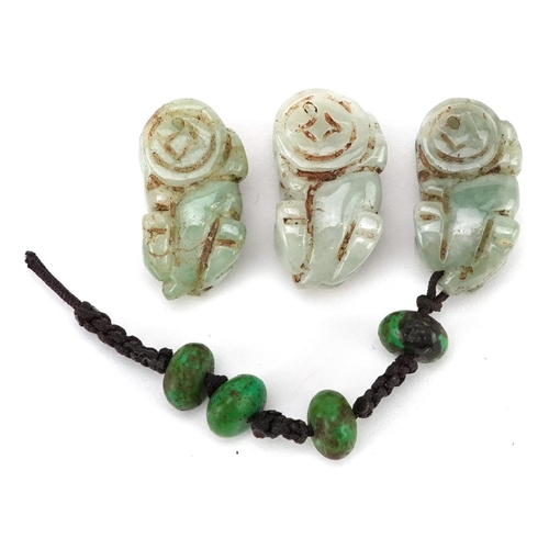 307 - Three Chinese carved celadon jade beads in the form of Foo dogs, early 20th century, 2cm in length.