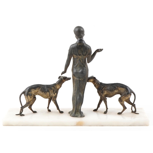  A French Art Deco silver plated study of a female standing with two Greyhounds raised on an onyx bas... 