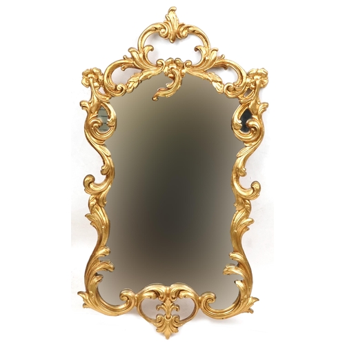 2116 - A late 20th century gilt framed scrollwork wall mirror, 70cm x 38cm.