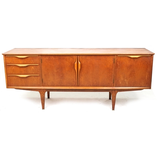 A mid 20th century teak sideboard by Jentique Furniture fitted with an arrangement of drawers and cupboards, raised on tapering legs, 74cm H x 183cm W x 45cm D.