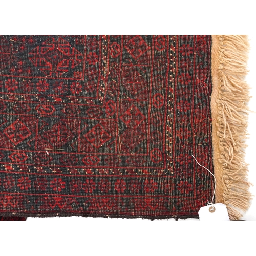 2036 - An Afghan Bukhara carpet, the midnight blue field with three centralized rows of guls within a compl... 