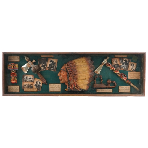 1077 - A 20th century stained pine display case enclosing reproduction Native American items alongside desc... 