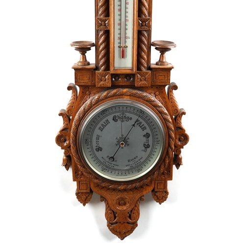 2168 - A late Victorian carved oak wall hanging barometer, 95cm in length.