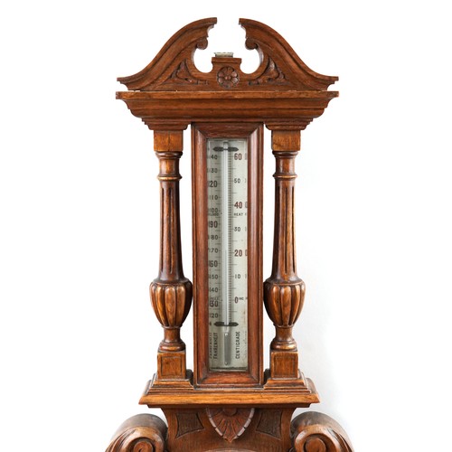 2170 - A late Victorian carved oak wall hanging aneroid barometer, 99cm in length.