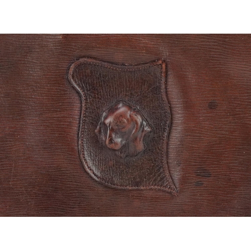 1134 - A French brown leather cartridge bag, circa 1900, decorated with a leather bust of a hound, W-24cm.