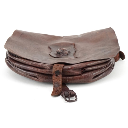 1134 - A French brown leather cartridge bag, circa 1900, decorated with a leather bust of a hound, W-24cm.