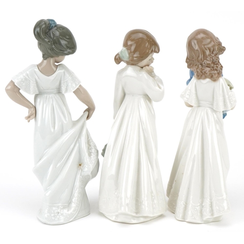 463 - Three Nao porcelain figures of young girls in nightwear, 21cm high.