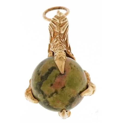 3410 - A yellow metal and hardstone charm in the form of a claw clutching a ball, 28.5mm high, 5.9g.