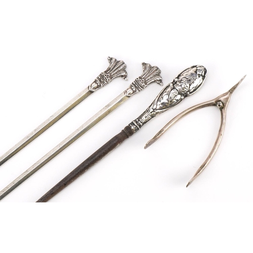 557 - Silver objects including a pair of meat skewers with Prince of Wales feathers and a pair of sugar to... 