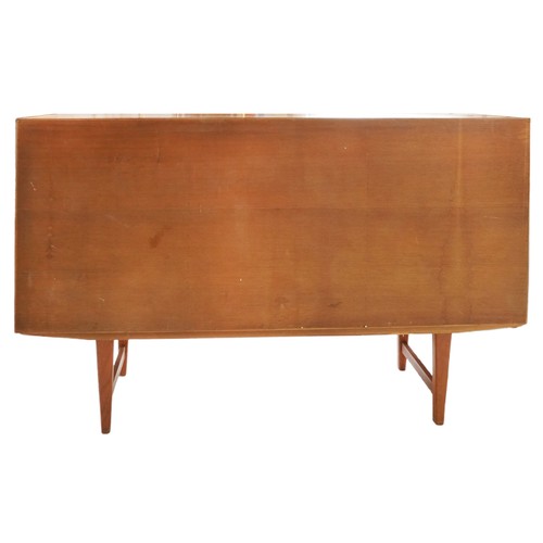 2010 - A mid 20th century teak sideboard fitted with sliding doors above three drawers, on tapering legs, 1... 