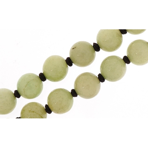 3130 - A Chinese pale green jade bead necklace, each bead 10.2mm in diameter, 120cm in length, 149.0g.