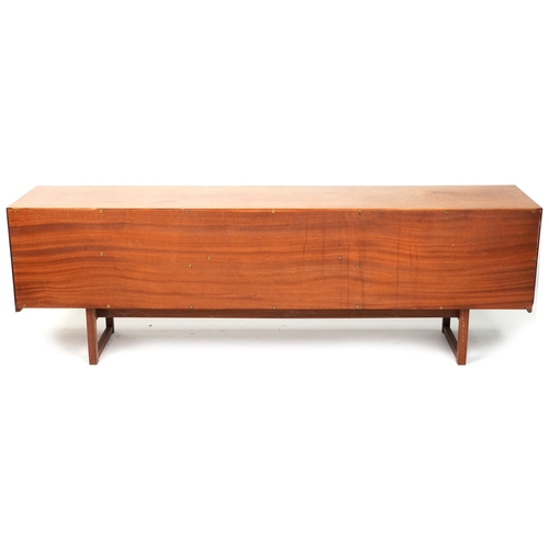 2003 - A mid 20th century teak sideboard fitted with three drawers and cupboards on sled supports.