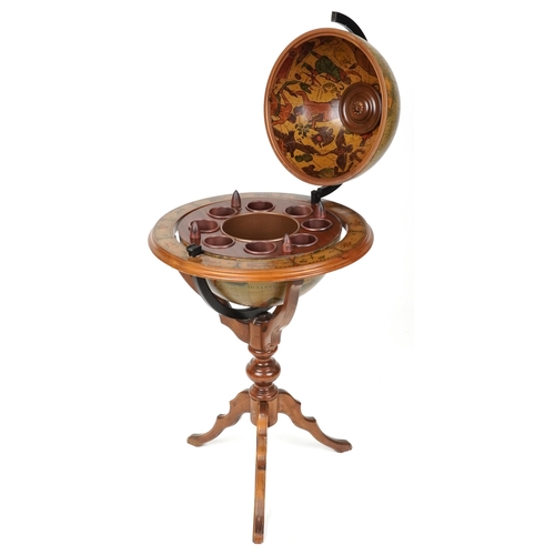 A late 20th century beech framed drinks terrestrial globe, the hinged top revealing a compartmentalized interior, raised on tripod legs, 106cm high x 56cm in diameter.