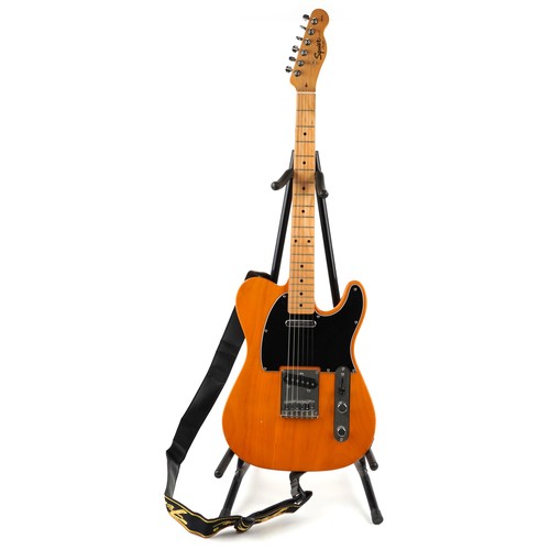 1038 - A Squire Telecaster six string electric guitar with natural wood finish and black scratch plate with... 