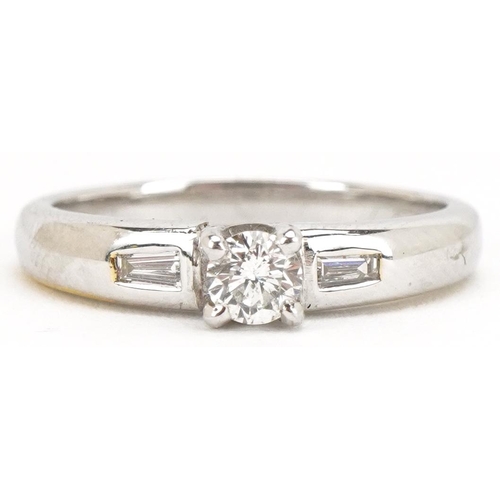 3032 - An 18ct white gold diamond solitaire ring with baguette cut diamond set shoulders, the solitaire app... 