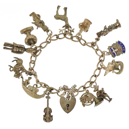 3483 - A silver charm bracelet with a collection of mostly silver charms including a Viking longboat, Frenc... 