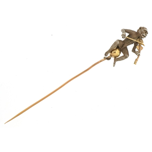 3146 - An antique unmarked gold, silver and yellow metal stickpin in the form of a monkey playing a violin,... 