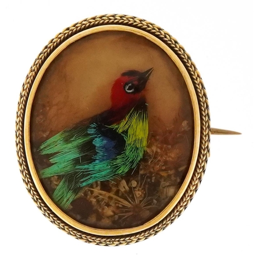 An antique unmarked 15ct gold mounted brooch hand painted with a bird of paradise, 2.5cm high, 5.8g.