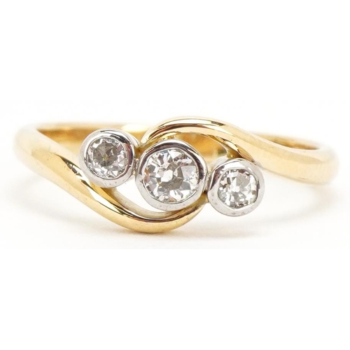 3027 - An 18ct gold diamond three stone crossover ring, the central diamond approximately 3.0mm in diameter... 