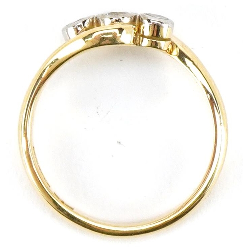 3027 - An 18ct gold diamond three stone crossover ring, the central diamond approximately 3.0mm in diameter... 