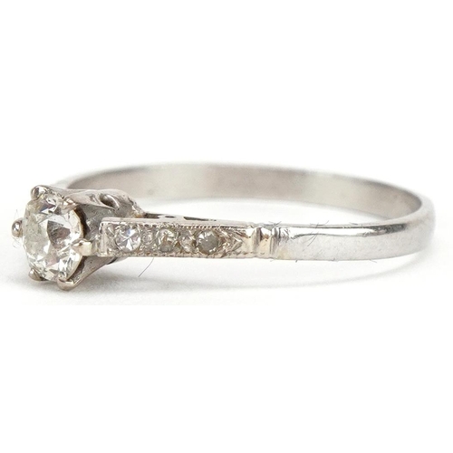 3063 - A platinum diamond solitaire ring with diamond set shoulders, the central diamond approximately 0.25... 