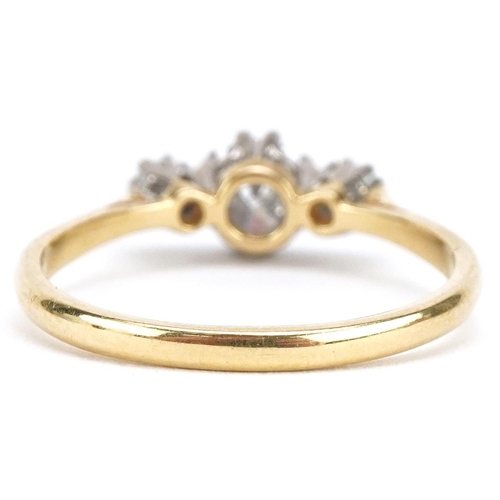 3034 - An 18ct gold diamond trilogy ring, the central diamond approximately 0.60 carat, size Q/R, 3.0g.