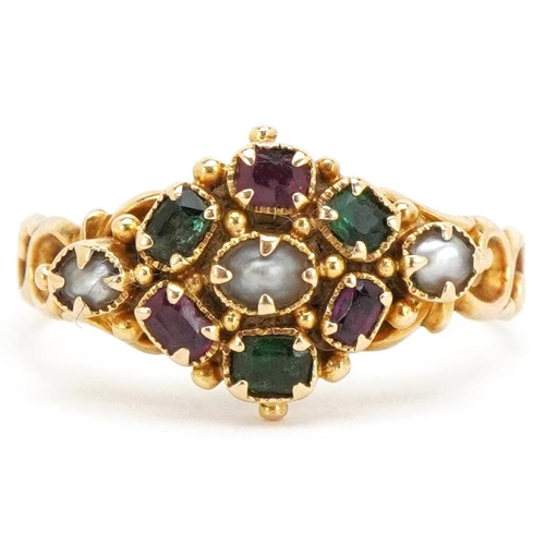 An early 20th century unmarked gold gem set ring in Suffragette colours, set with rubies, emeralds and pearls in an ornate setting, size O.