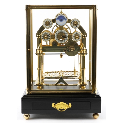 97 - A Congreve style rolling ball clock housed under a glazed brass display case with ebonised base and ... 