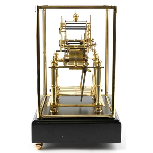 97 - A Congreve style rolling ball clock housed under a glazed brass display case with ebonised base and ... 