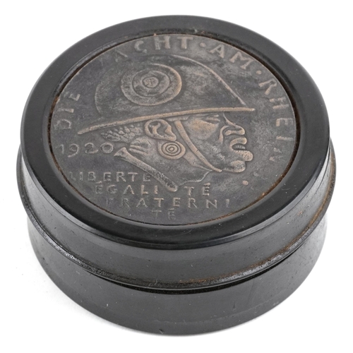 2481 - A German military interest ebonised snuff box, 6.5cm in diameter.