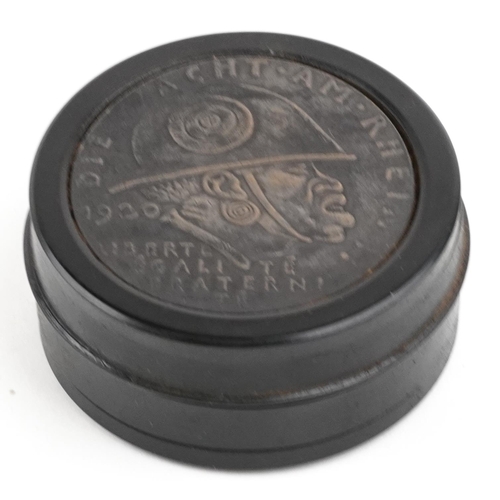 2481 - A German military interest ebonised snuff box, 6.5cm in diameter.