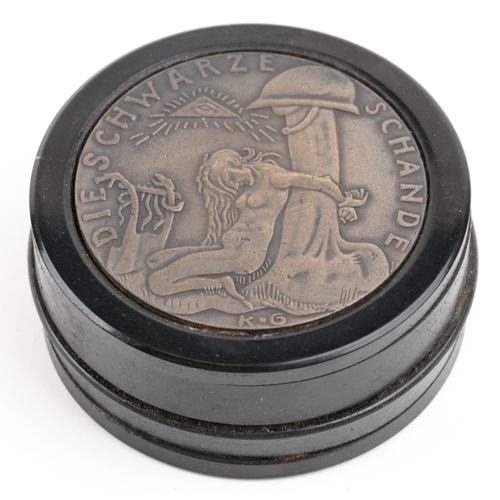 2481 - A German military interest ebonised snuff box, 6.5cm in diameter.