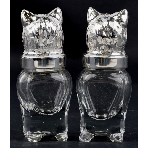 1080 - A pair of novelty glass salt and pepper casters with silver plated heads in the form of cats, each 1... 