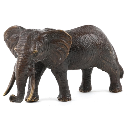 1065 - A Japanese patinated bronze okimono of an elephant, 20th century, 30cm in length.