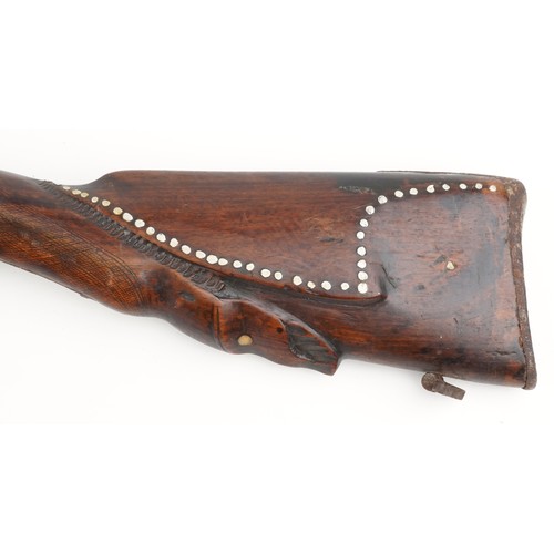 2554 - An antique Middle Eastern double barrel flintlock rifle, the wooden stock carved with a serpent head... 