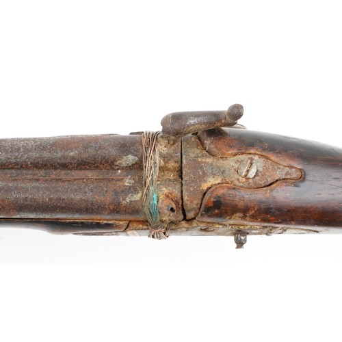 2554 - An antique Middle Eastern double barrel flintlock rifle, the wooden stock carved with a serpent head... 