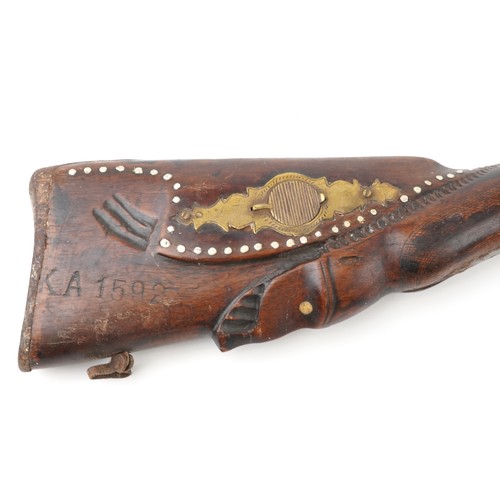 2554 - An antique Middle Eastern double barrel flintlock rifle, the wooden stock carved with a serpent head... 