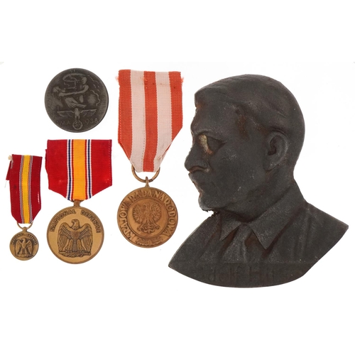 2422 - Four German military interest medals and a cast iron plaque of Adolf Hitler.