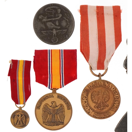 2422 - Four German military interest medals and a cast iron plaque of Adolf Hitler.