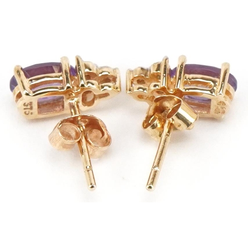 3204 - A pair of 9ct gold amethyst and diamond stud earrings, 9.6mm high, total 1.1g.