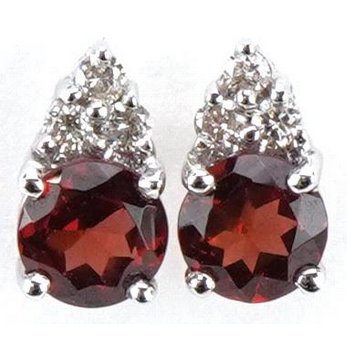 3180 - A pair of 18ct white gold garnet solitaire and diamond stud earrings, 7.2mm high, total 1.3g.