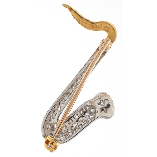 3167 - An 18ct two tone gold pavé set diamond brooch in the form of a saxophone, 3.2cm high, 3.1g.