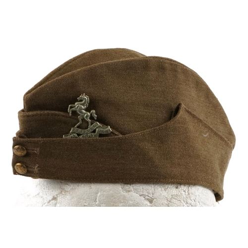 2477 - A British military World War II side cap with Royal Kent West cap badge, stamped marks to the interi... 