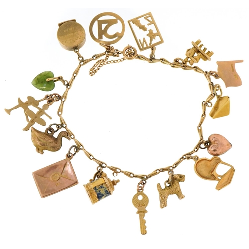 3003 - A 9ct gold charm bracelet with a collection of mostly gold charms including a kiwi, enamelled tankar... 