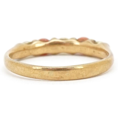 3495 - A 9ct gold coral and seed pearl half eternity ring, size I, 1.4g.