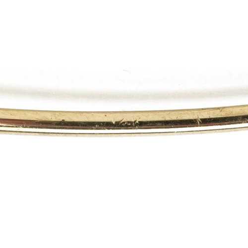 3105 - A 14ct gold adjustable bangle set with two sapphires, 6.5cm in diameter, 4.5g.